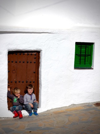 Sitting on the doorstep of a whitewashed house, Comares, Andalucia
